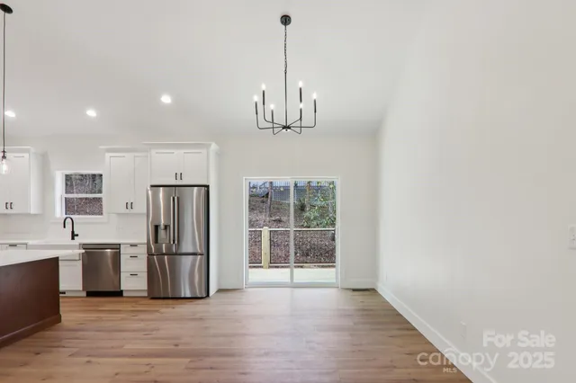 a view of a kitchen with a refrigerator cabinets and a wooden floor