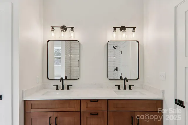 a bathroom with double vanity sinks and a mirror