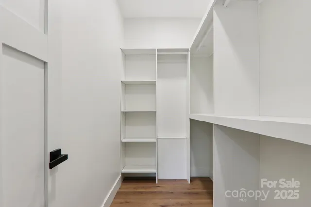 a view of walk in closet with empty racks