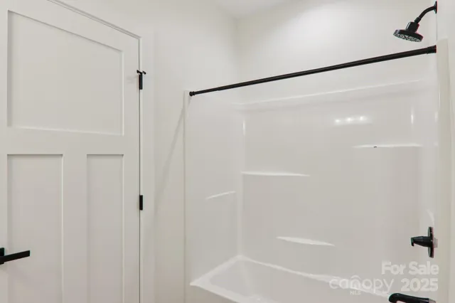 an empty room with wooden floor chandelier fan and windows