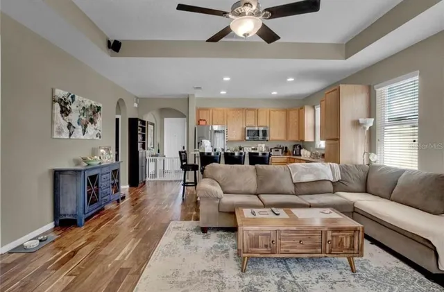 a living room with furniture kitchen view and a window