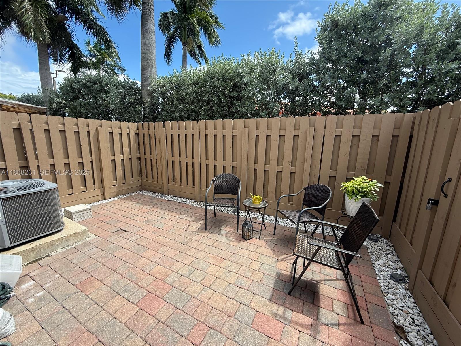 400 Northeast 208th Terrace, Unit 400 Miami, FL 33179 - Photo 17 of 53 a chairs and a table in a backyard