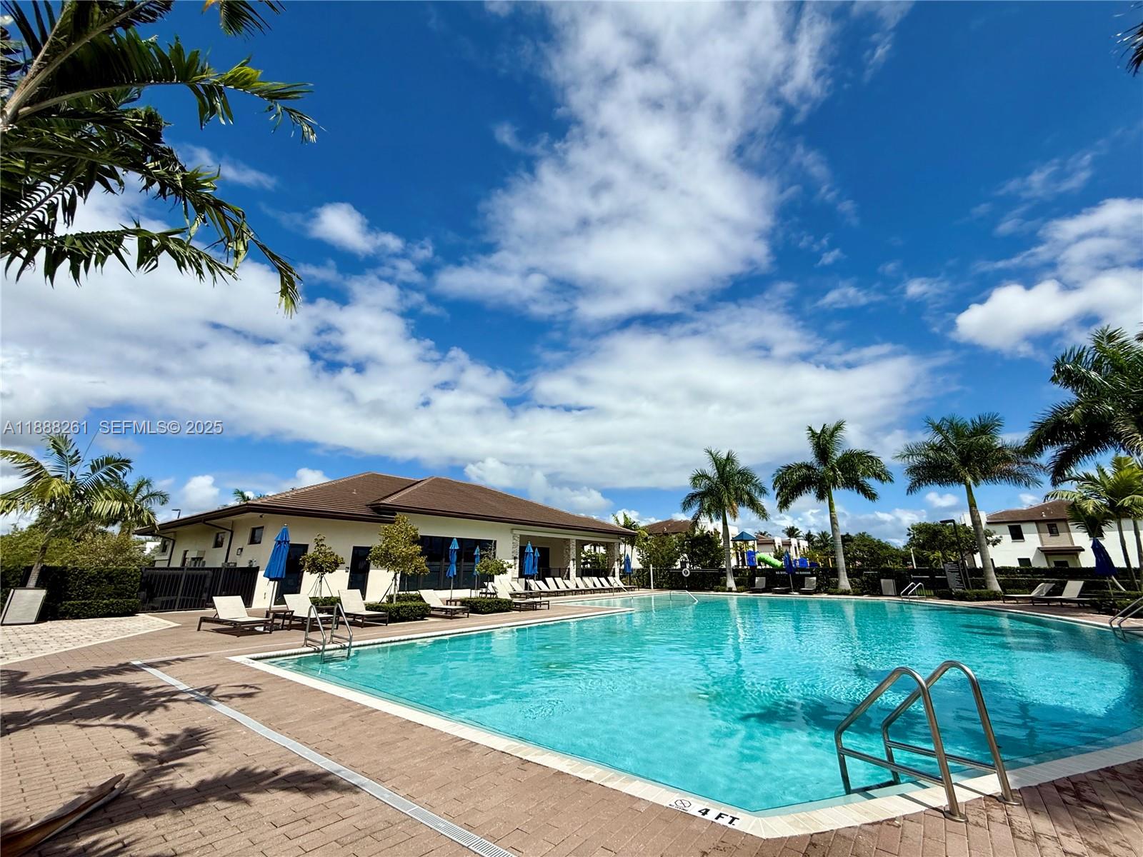 400 Northeast 208th Terrace, Unit 400 Miami, FL 33179 - Photo 19 of 53 a view of a swimming pool and a lot of trees in the background