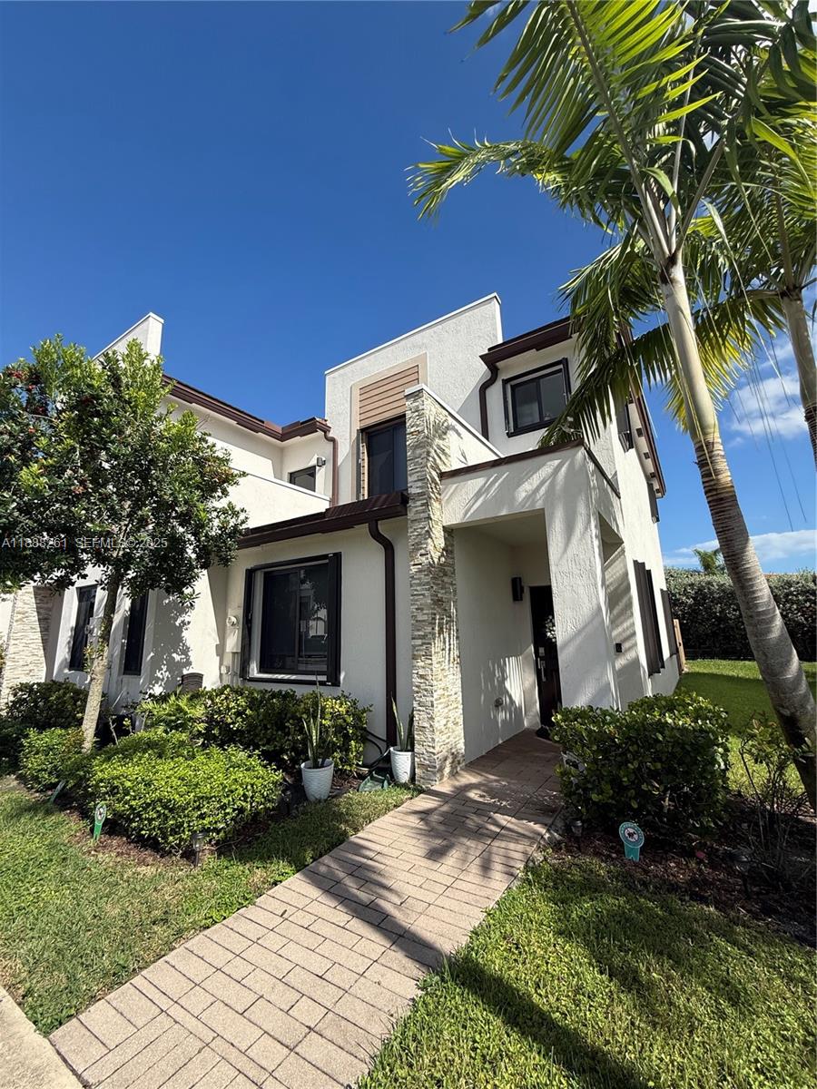 400 Northeast 208th Terrace, Unit 400 Miami, FL 33179 - Photo 23 of 53 a front view of a house with garden