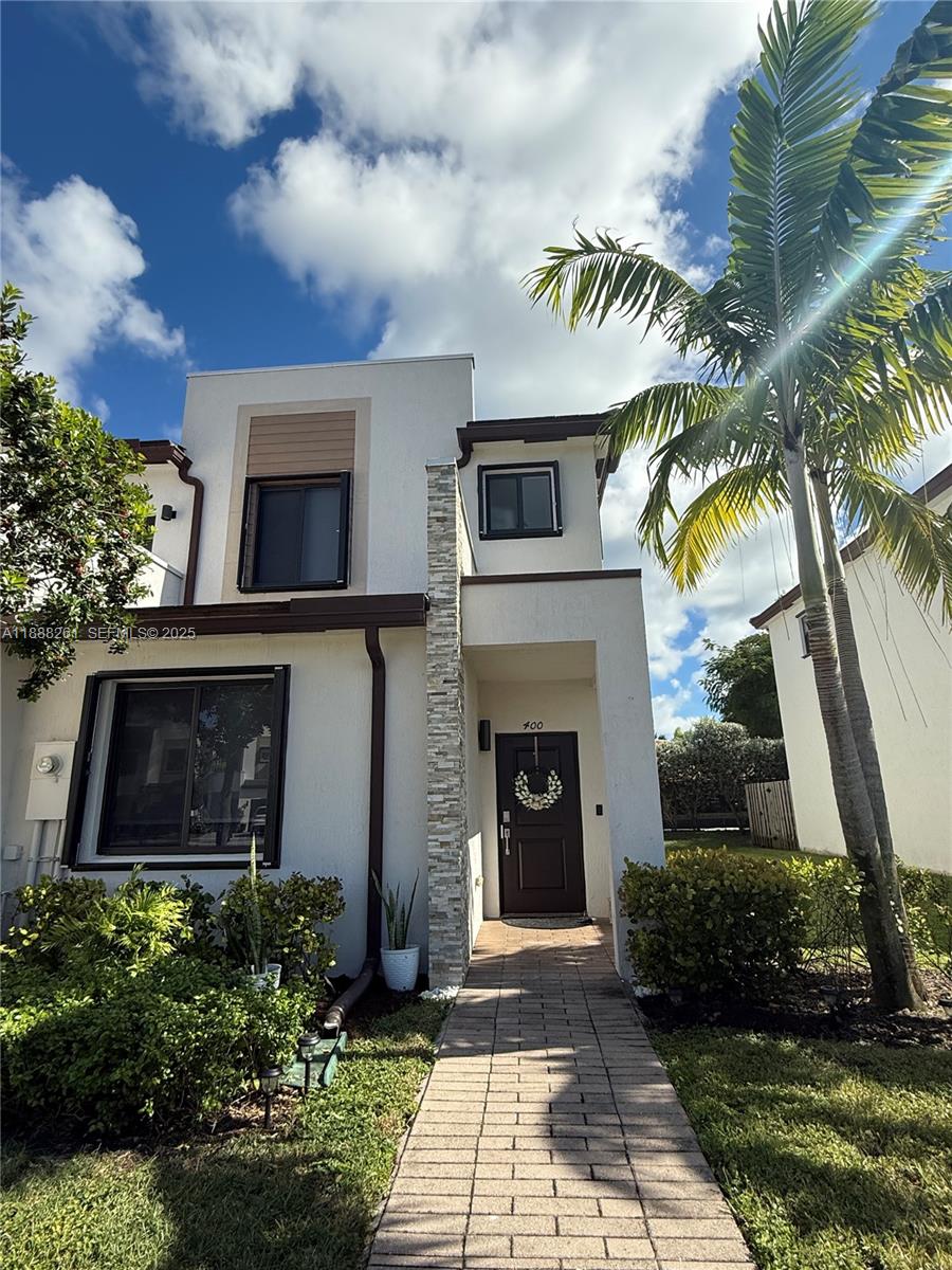 400 Northeast 208th Terrace, Unit 400 Miami, FL 33179 - Photo 3 of 53 a front view of a house with a yard
