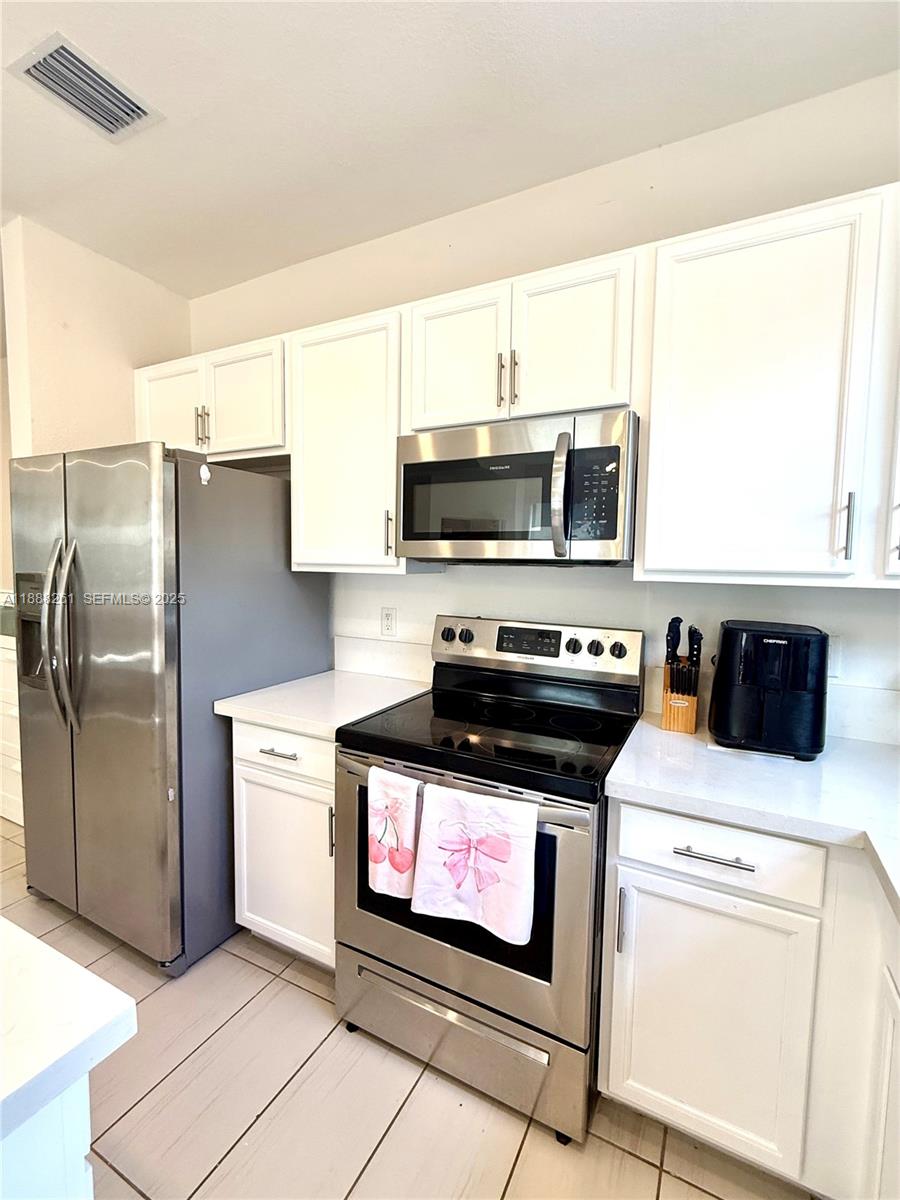 400 Northeast 208th Terrace, Unit 400 Miami, FL 33179 - Photo 38 of 53 a kitchen with a stove a microwave and refrigerator