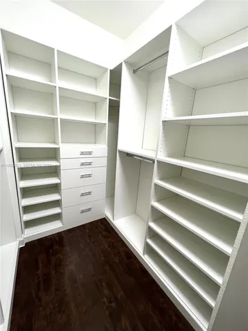 a view of walk in closet with empty racks