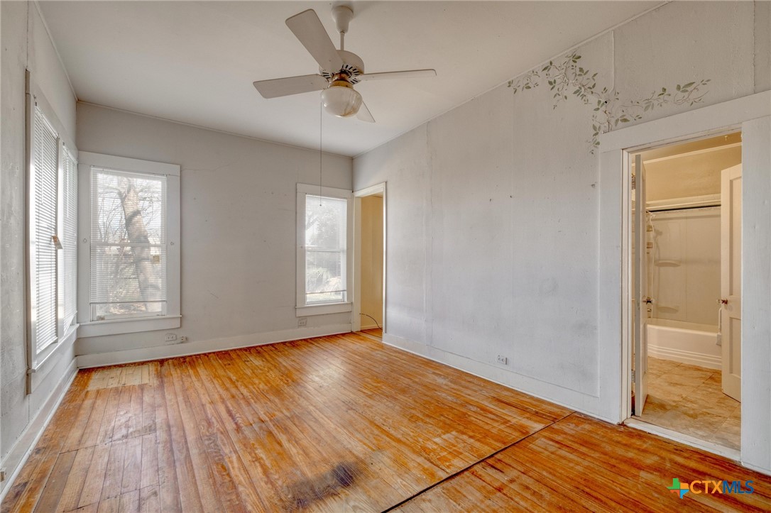 409 East Bowie Street Luling, TX 78648 - Photo 14 of 22 wooden floor in an empty room with a window
