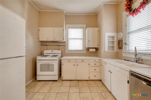 a kitchen with a stove sink and cabinets