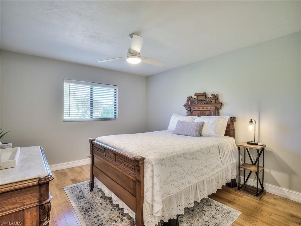 106 Cherry Hill Court Naples, FL 34113 - Photo 11 of 19 a bedroom with a bed and a table in it
