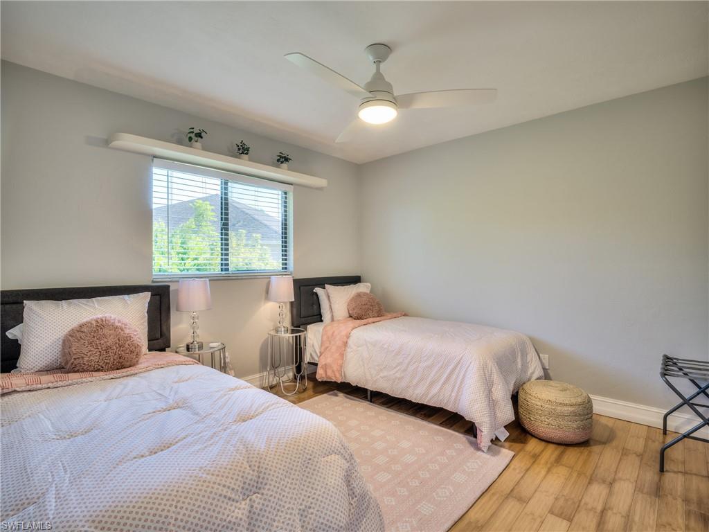 106 Cherry Hill Court Naples, FL 34113 - Photo 12 of 19 a bedroom with two beds and a large window