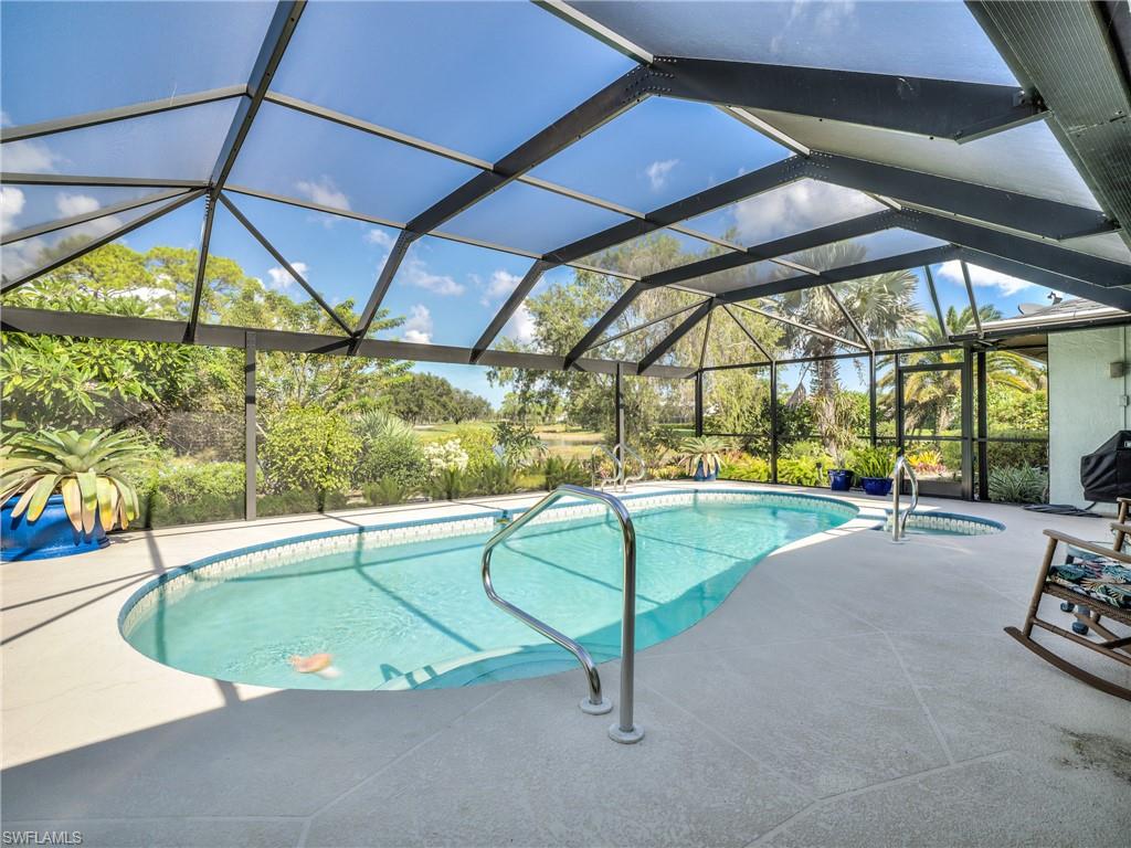106 Cherry Hill Court Naples, FL 34113 - Photo 13 of 19 a view of a swimming pool with a patio and a yard