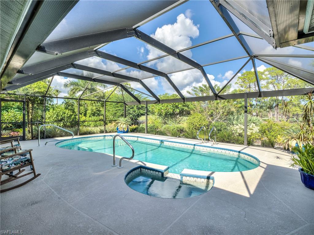 106 Cherry Hill Court Naples, FL 34113 - Photo 14 of 19 a view of backyard with a table and chairs under an umbrella