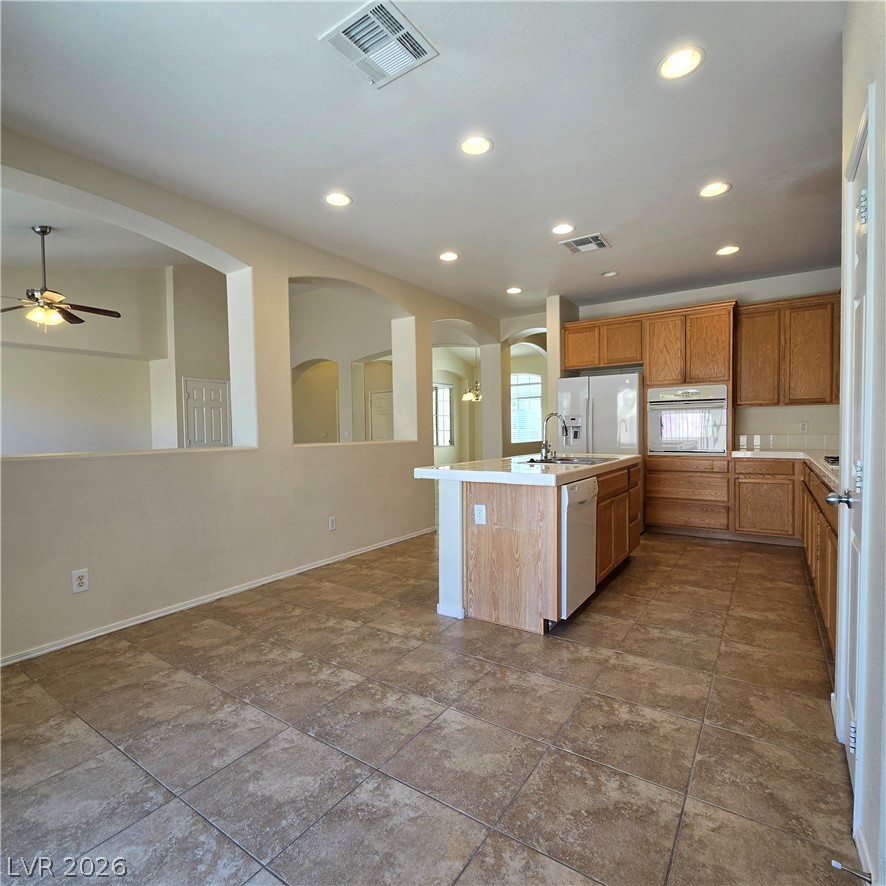 9234 Kingston Road Henderson, NV 89074 - Photo 15 of 38 An inviting open-concept kitchen features a functional island and warm wood cabinetry.