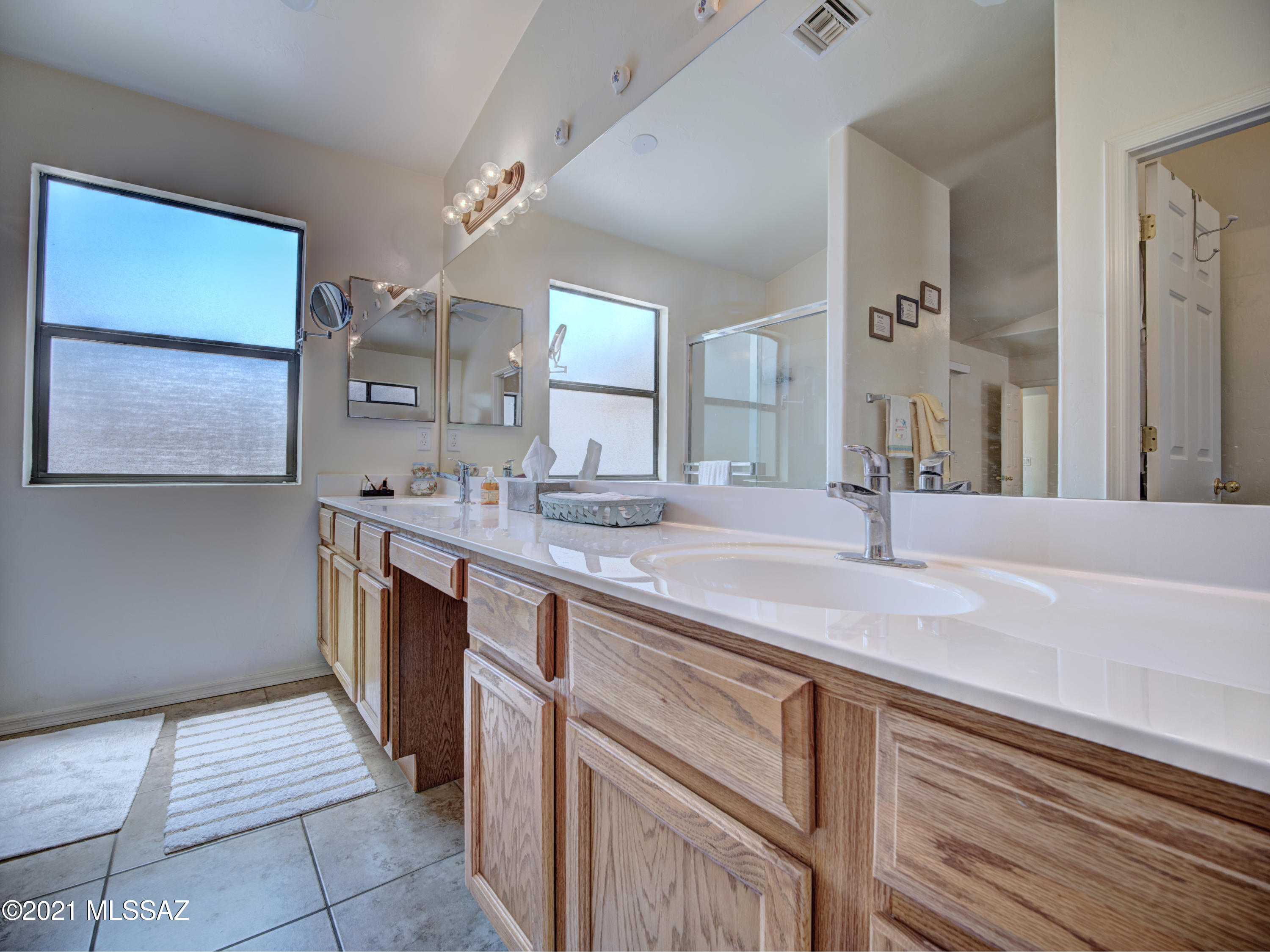 434 Colorado Court Rio Rico, AZ 85648 - Photo 24 of 29 a spacious bathroom with a granite countertop sink and a mirror