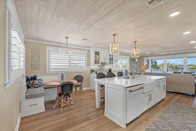 a kitchen with a dining table chairs and white cabinets