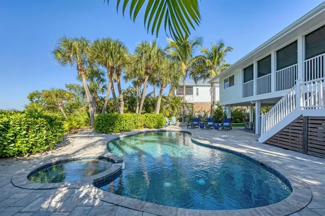 a patio with a table and chairs plants and a barbeque