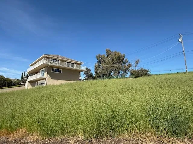 a blue house with green field in front of it