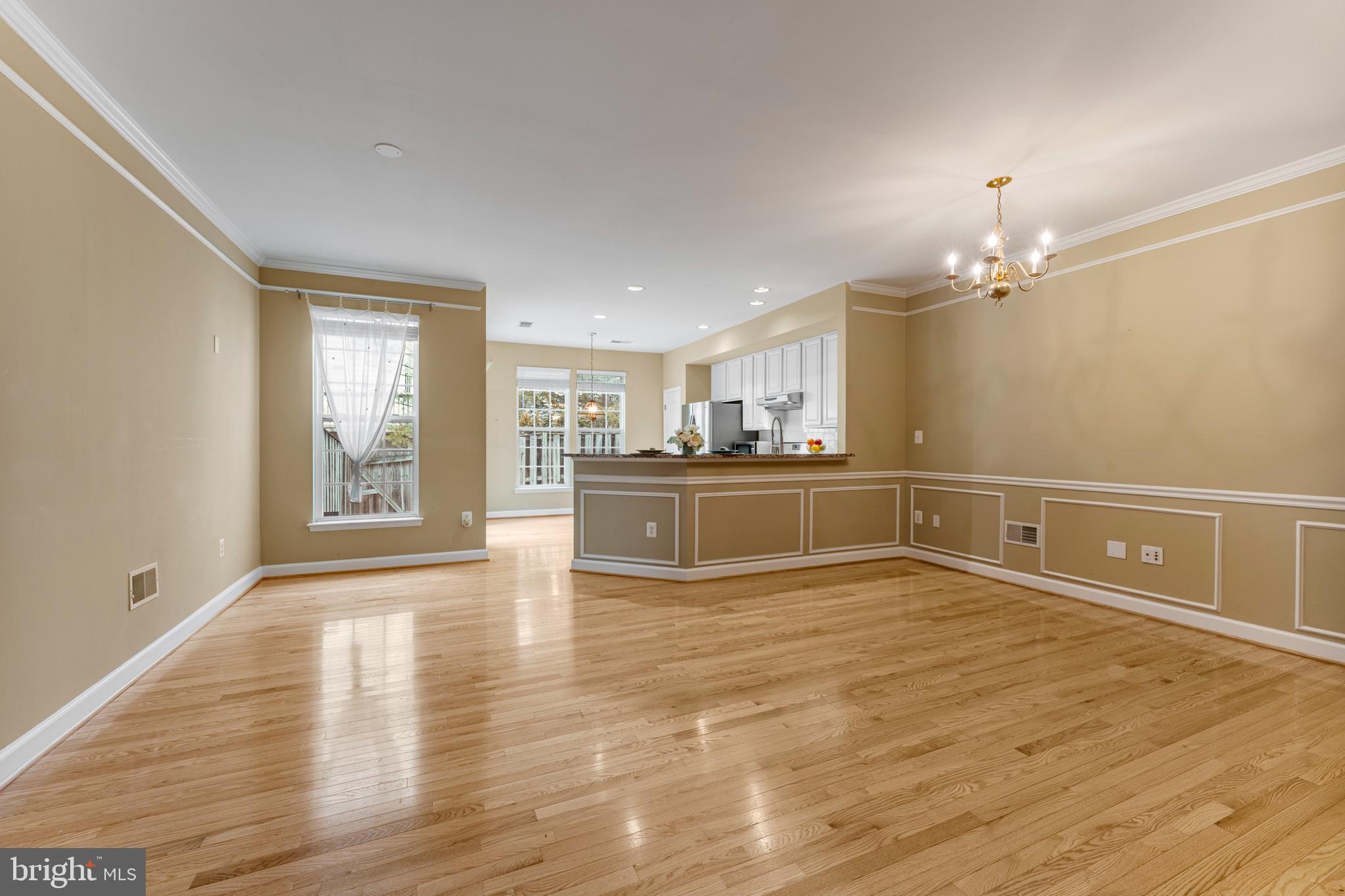 6002 St Hubert Lane Centreville, VA 20121 - Photo 3 of 27 a view of a kitchen with kitchen island a sink wooden floor and a large window