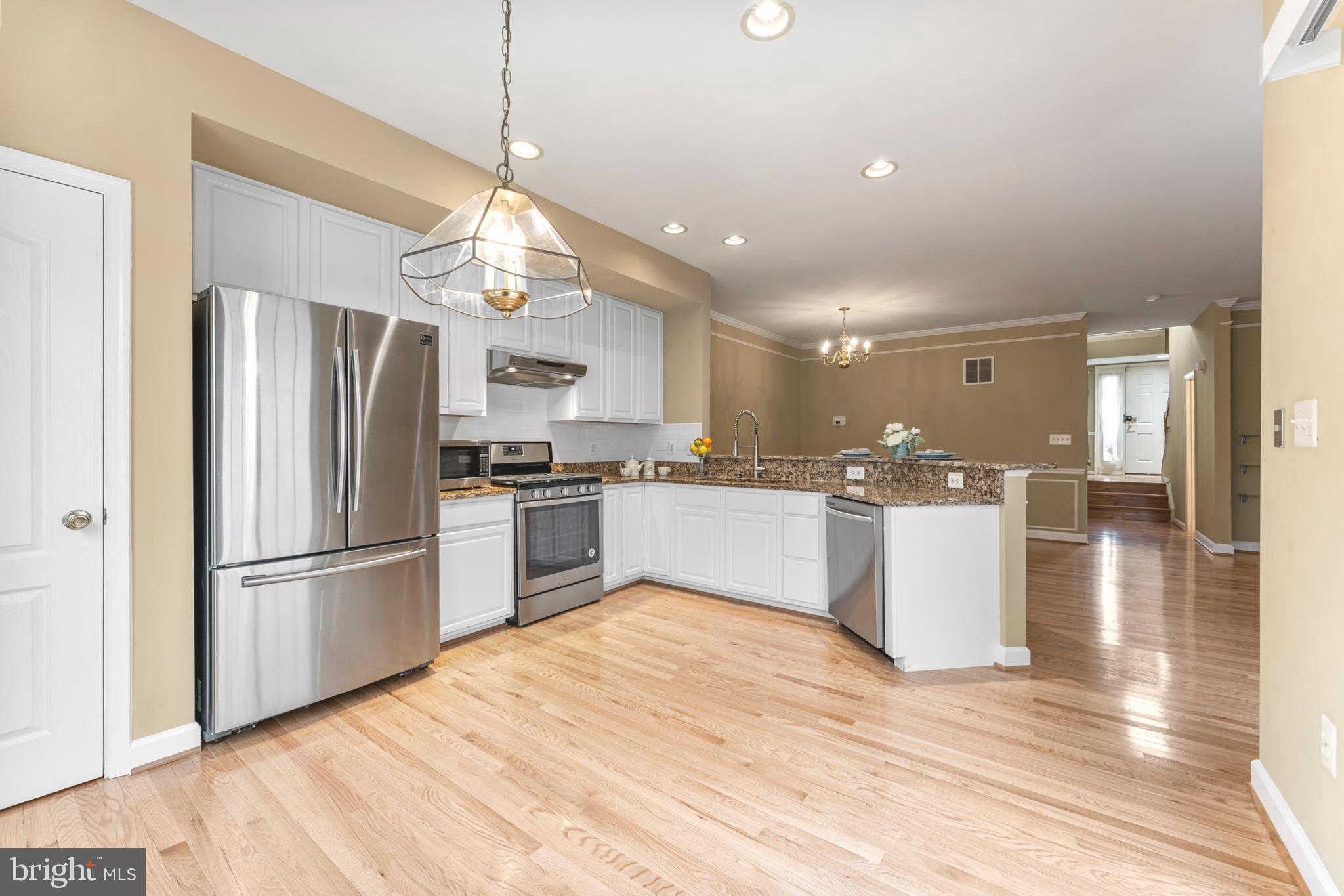 6002 St Hubert Lane Centreville, VA 20121 - Photo 5 of 27 a kitchen with refrigerator cabinets and wooden floor