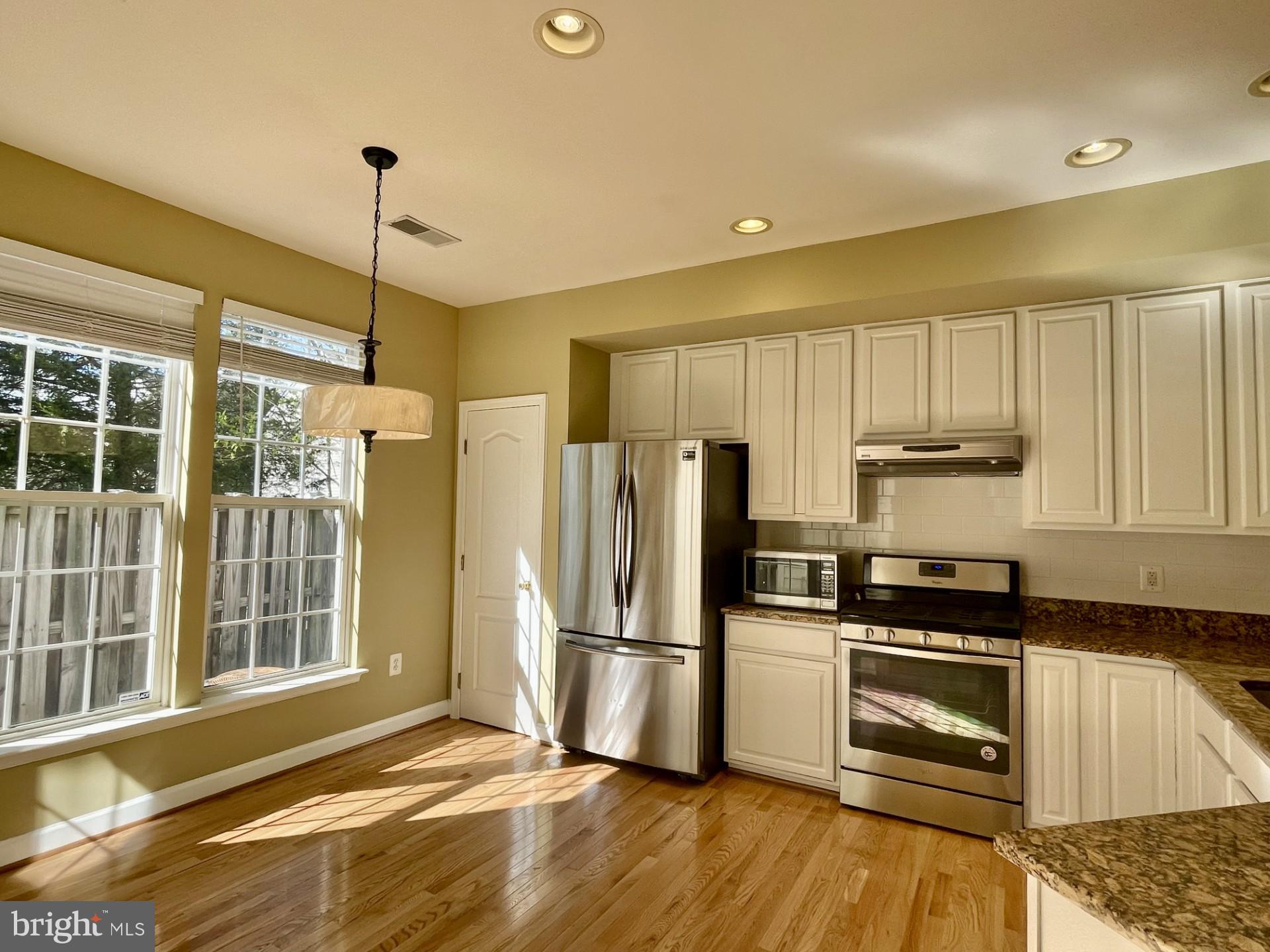 6002 St Hubert Lane Centreville, VA 20121 - Photo 6 of 27 a kitchen with granite countertop a refrigerator and a stove top oven