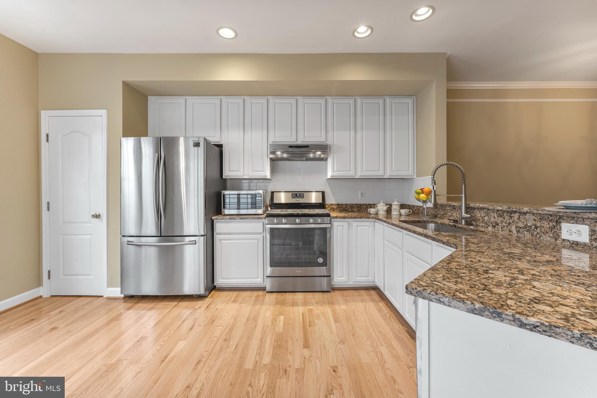6002 St Hubert Lane Centreville, VA 20121 - Photo 7 of 27 a kitchen with granite countertop a refrigerator and a stove top oven