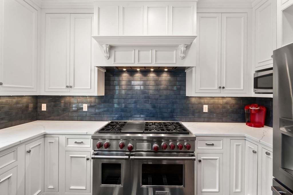 29 Maple Lane, Unit 29 Medfield, MA 02052 - Photo 13 of 42 a kitchen with stainless steel appliances granite countertop a stove and a white cabinets