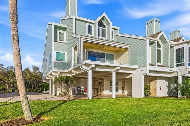 a view of a white house with a big yard and large trees