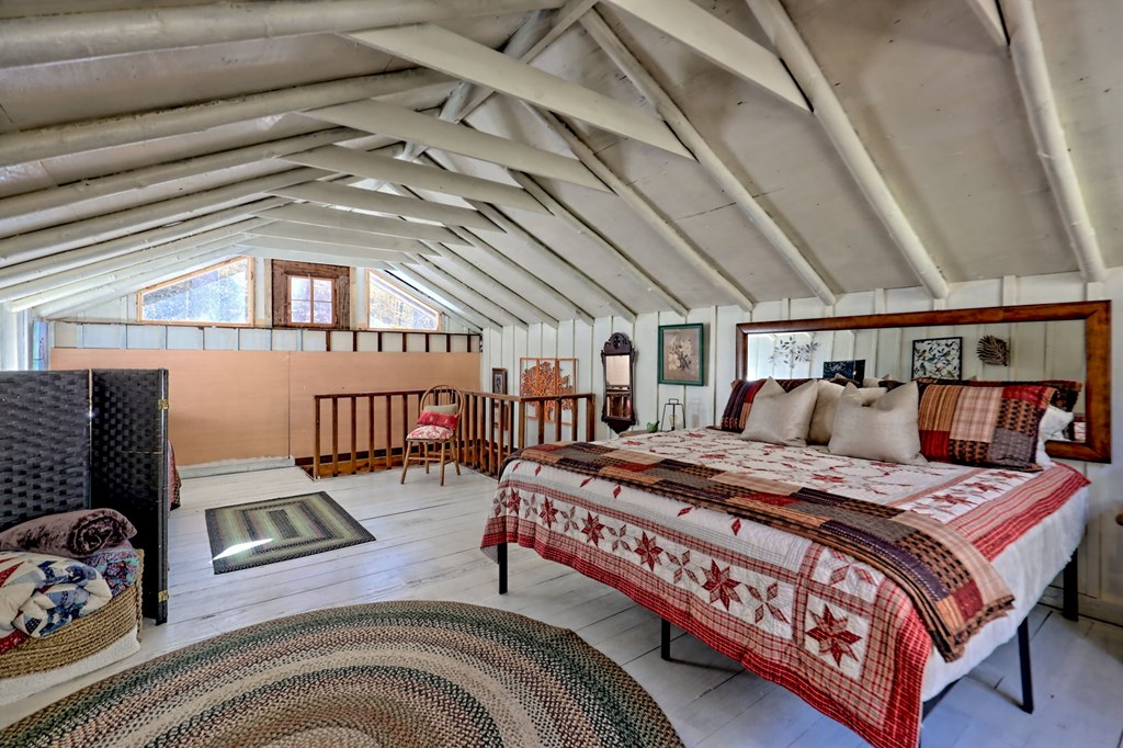 1307 Clear Creek Road Hayesville, NC 28904 - Photo 32 of 65 a bed sitting in a bedroom next to a window
