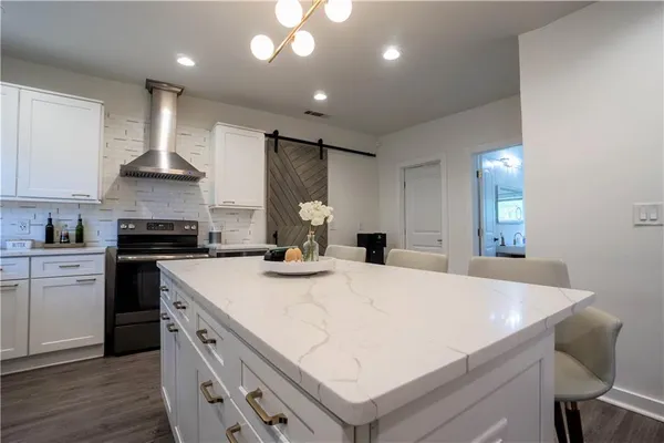 a large white kitchen with sink stove and cabinets