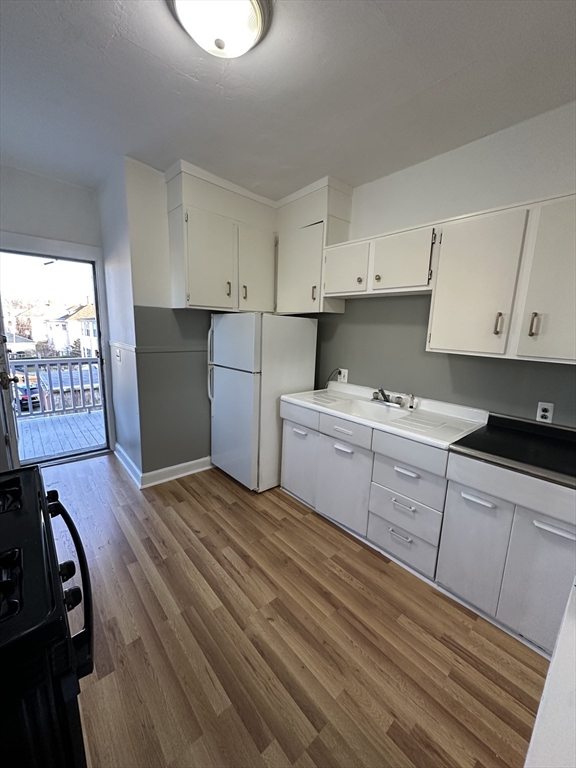 1076 Washington Street, Unit 3 Norwood, MA 02062 - Photo 5 of 8 a kitchen with a stove a refrigerator and cabinets