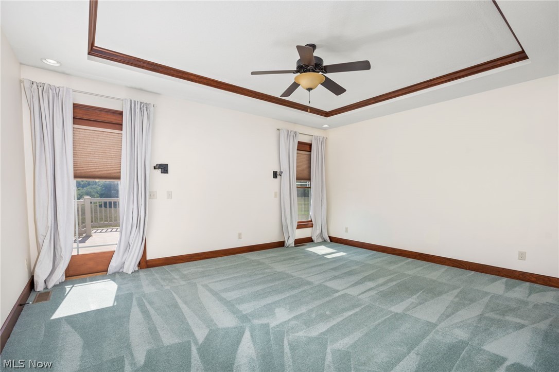 6925 River Styx Road Medina, OH 44256 - Photo 18 of 49 Spacious room with a tray ceiling featuring dark wood trim, recessed lighting, and a ceiling fan