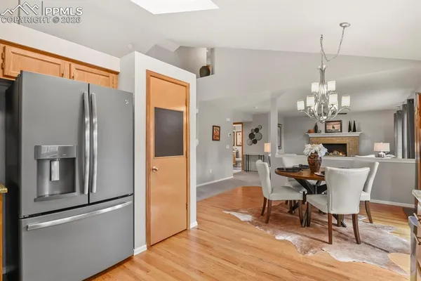 a view of a dining room with furniture a chandelier and wooden floor