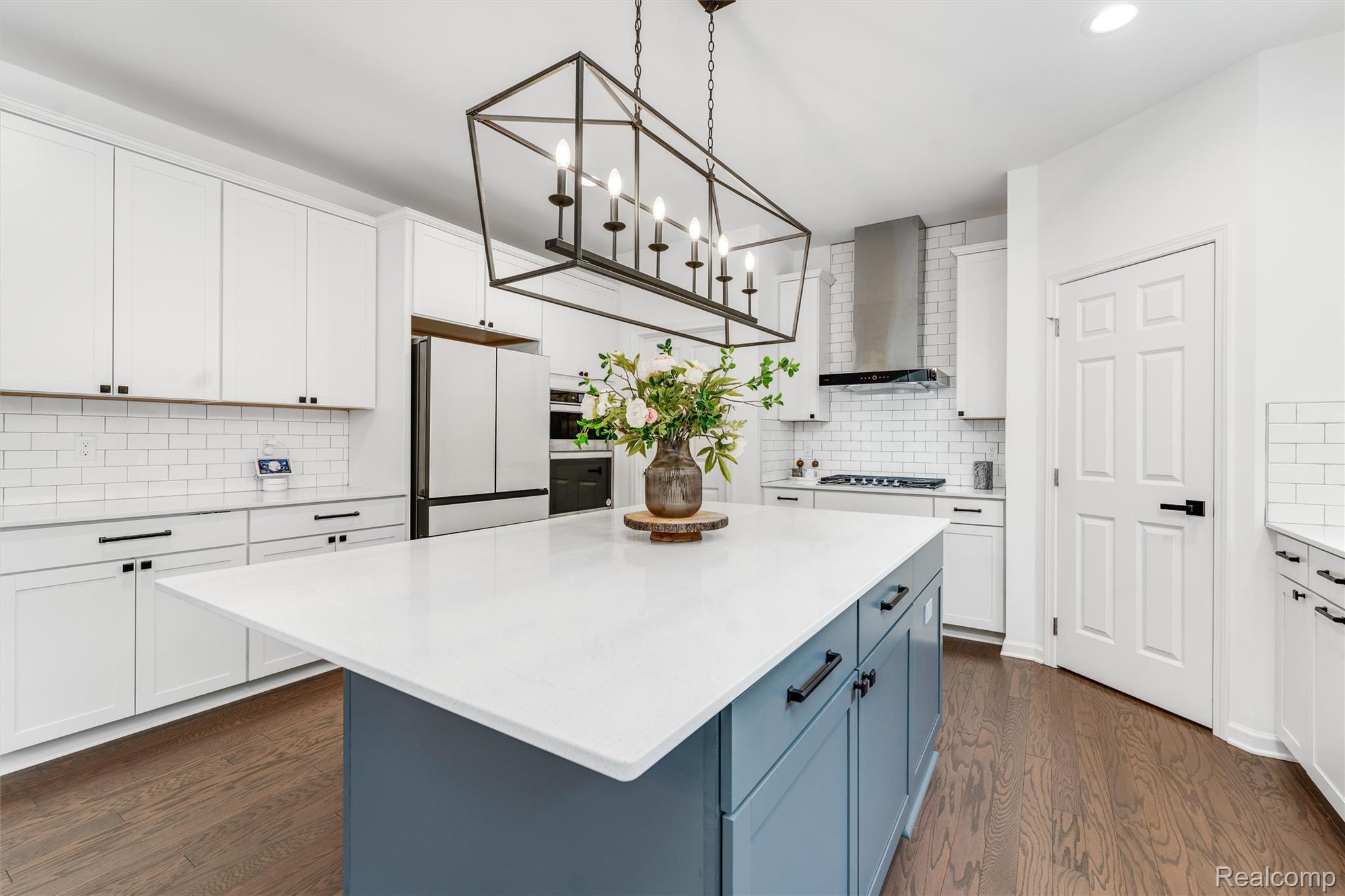 908 South Livernois Road Rochester, MI 48309 - Photo 6 of 49 Dual tone kitchen with dual tone cabinets, a kitchen island, freestanding refrigerator, dark wood-type flooring, and light stone countertops
