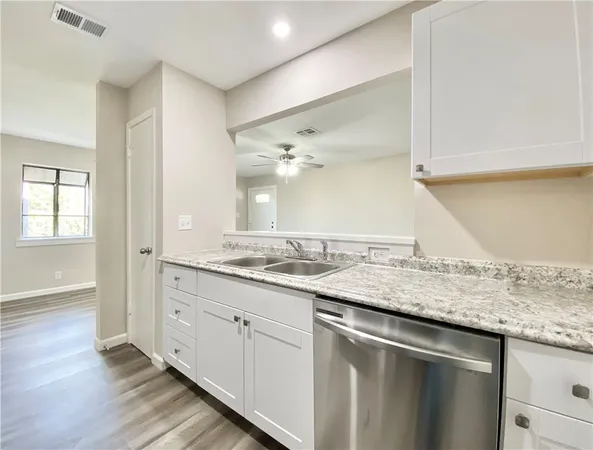 a kitchen with stainless steel appliances a white cabinet and a stove top oven