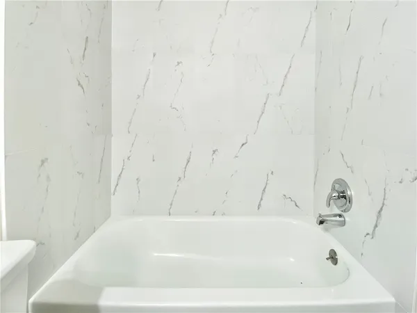 a front view of a house with a yard and tree