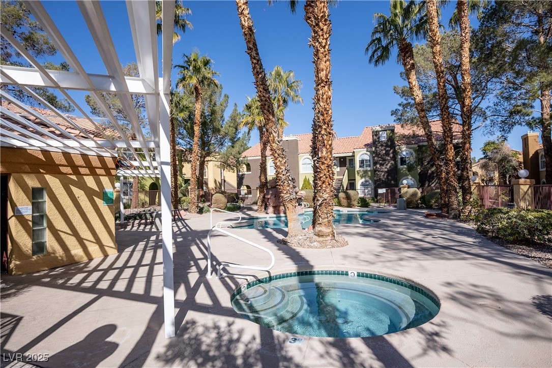 7950 West Flamingo Road, Unit 1173 Las Vegas, NV 89147 - Photo 29 of 31 Pool featuring a patio, fence, a hot tub, and a pergola