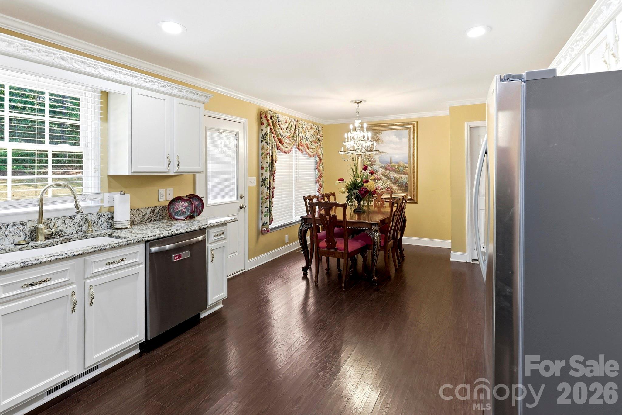 327 Sherry Street Rutherfordton, NC 28139 - Photo 6 of 22 a kitchen with stainless steel appliances granite countertop a stove a refrigerator a sink a dining table and chairs with wooden floor
