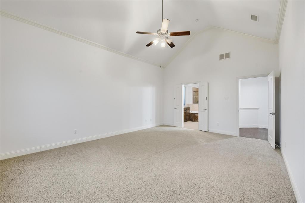 1321 Talley Lane Frisco, TX 75033 - Photo 15 of 40 Unfurnished bedroom featuring high vaulted ceiling, light colored carpet, ornamental molding, a ceiling fan, and ensuite bathroom