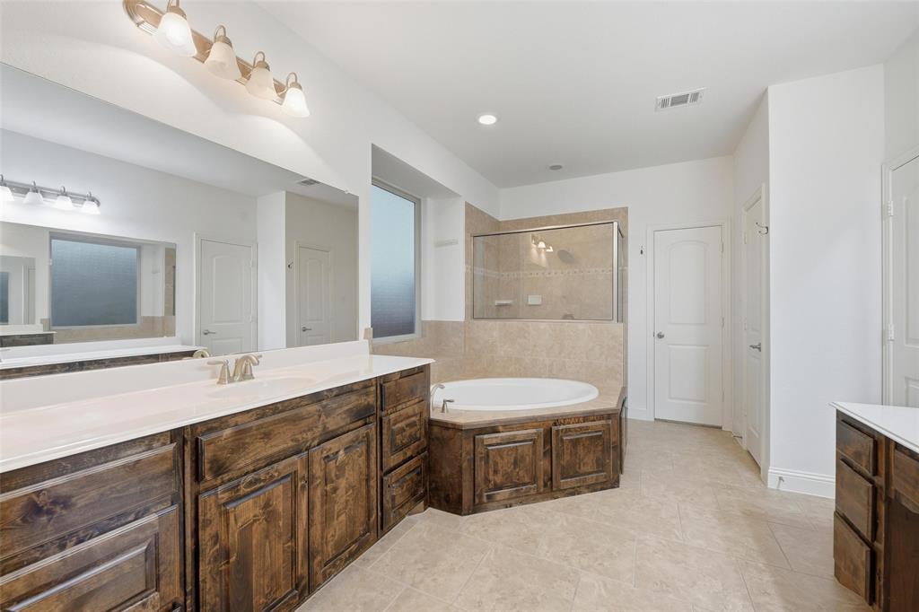 1321 Talley Lane Frisco, TX 75033 - Photo 17 of 40 Bathroom with a stall shower, vanity, light tile patterned floors, a garden tub, and a closet