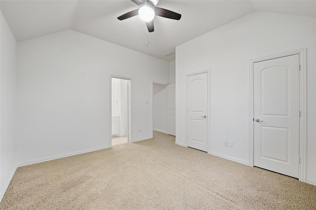 1321 Talley Lane Frisco, TX 75033 - Photo 30 of 40 Unfurnished bedroom with vaulted ceiling, light carpet, connected bathroom, and ceiling fan