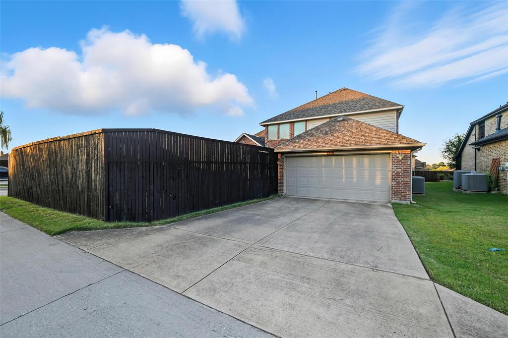 1321 Talley Lane Frisco, TX 75033 - Photo 37 of 40 View of home's exterior featuring brick siding, concrete driveway, and a shingled roof