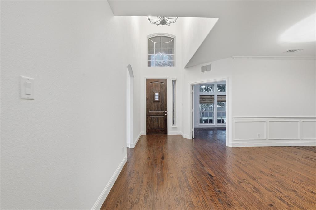 1321 Talley Lane Frisco, TX 75033 - Photo 4 of 40 Foyer entrance with dark wood-type flooring, a high ceiling, and arched walkways