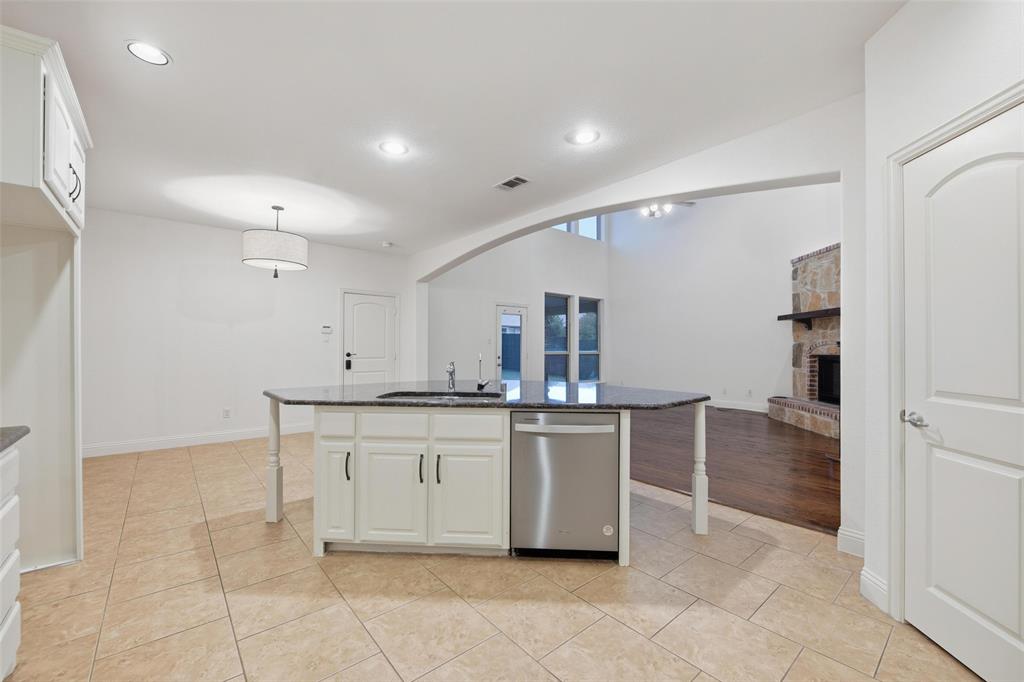1321 Talley Lane Frisco, TX 75033 - Photo 10 of 40 Kitchen with white cabinetry, light tile patterned flooring, dark stone countertops, a breakfast bar area, and recessed lighting