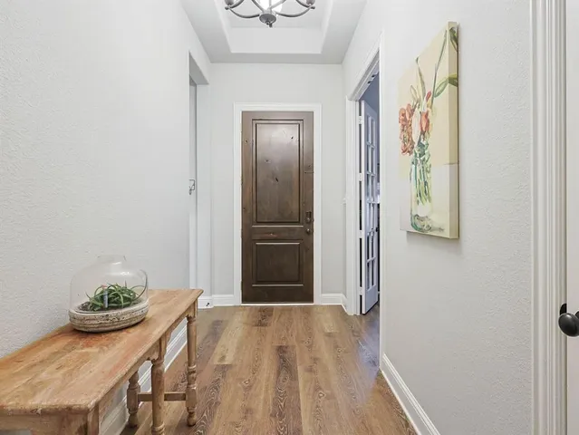 a view of a hallway with wooden floor and chair