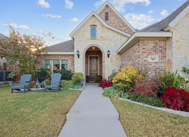 a front view of a house with a porch and a garden