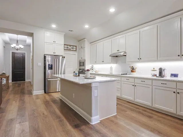 a kitchen with white cabinets and stainless steel appliances