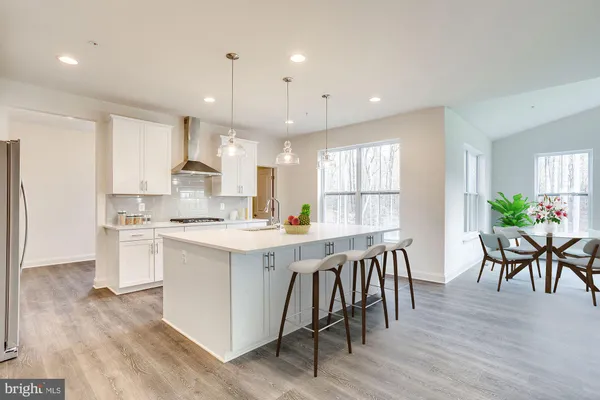 a large kitchen with kitchen island a island a stove a table and chair in it