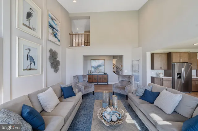 a living room with furniture couches and a dining table with wooden floor