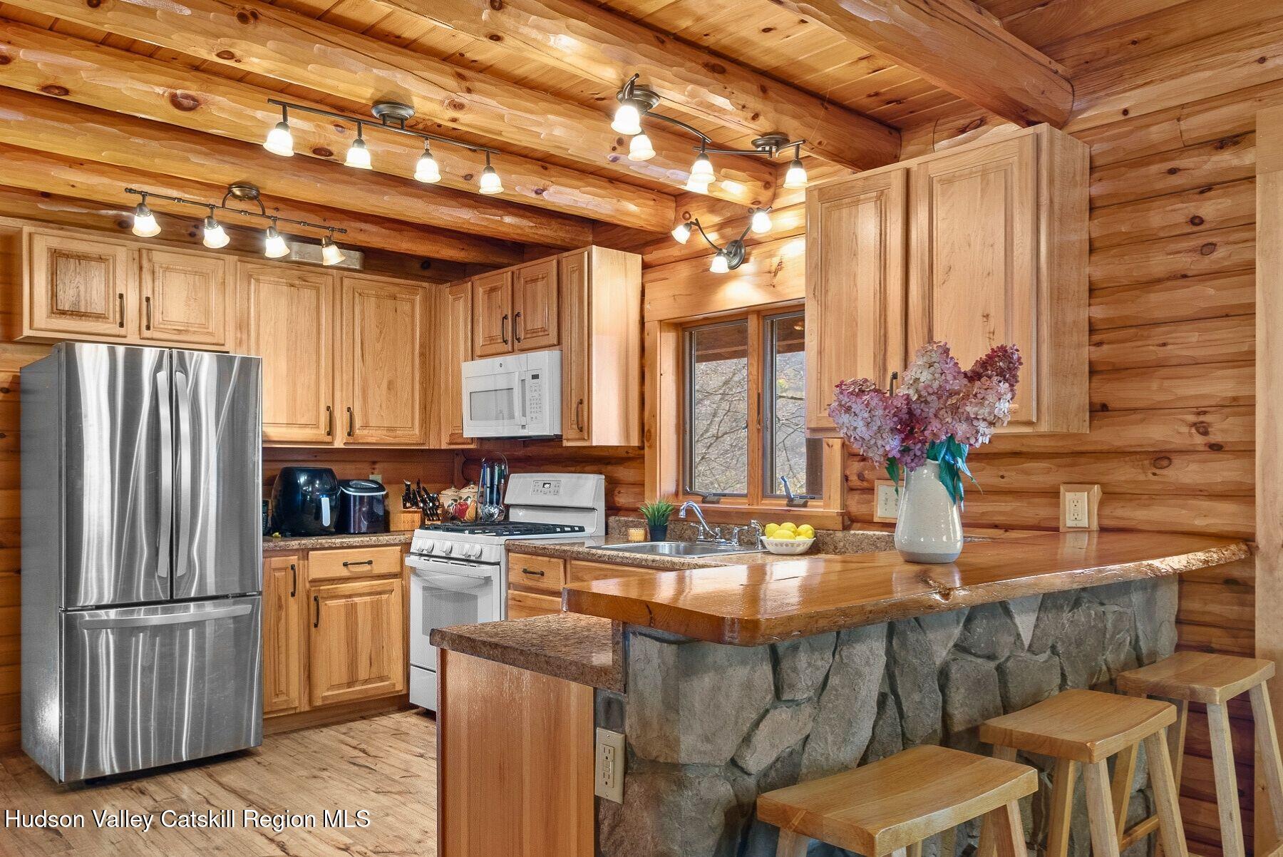 281 Turk Hollow Road Fleischmanns, NY 12430 - Photo 11 of 30 a kitchen with kitchen island granite countertop a table chairs refrigerator and cabinets